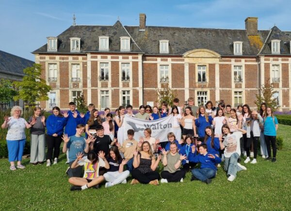 Group photo of Walton Academy Year 8 students and staff standing outside Le Château de Chantereine accommodation during their Normandy Trip 2025.